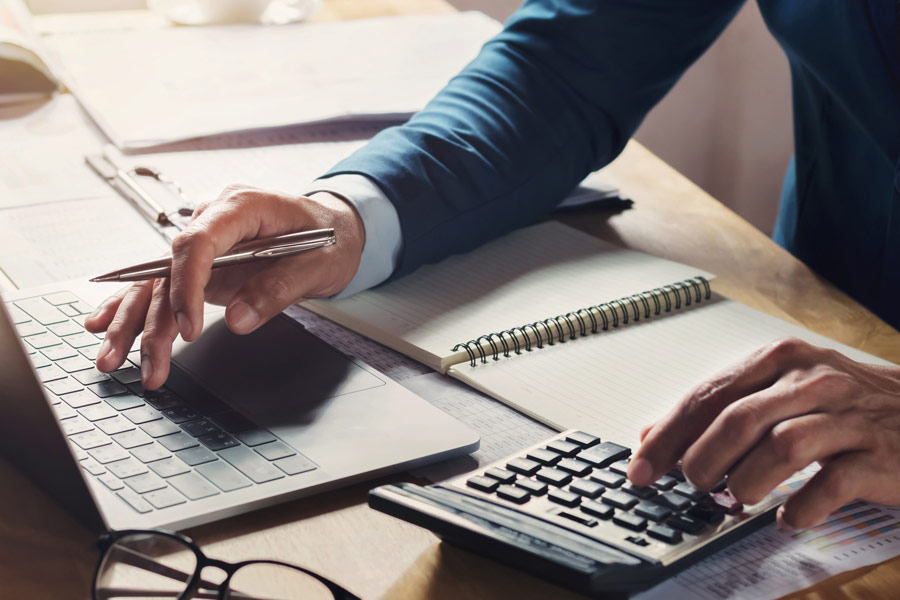Comptable d'un cabinet de syndic vérifiant la balance des fonds mandants sur son logiciel métier
